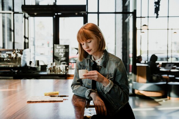 Femme ayant une tasse de café dans un café