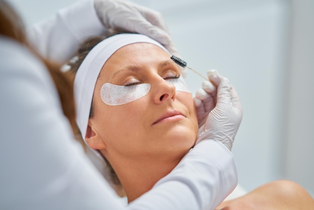 Femme ayant un traitement des sourcils de cosmétologie dans un salon de beauté