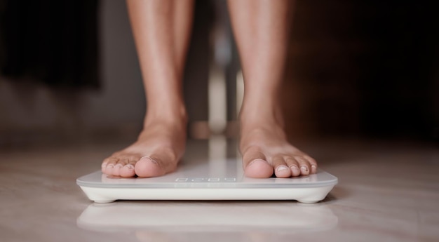 Femme sur les balances mesurer le poids Suivre un régime féminin contrôler la perte de poids IMC