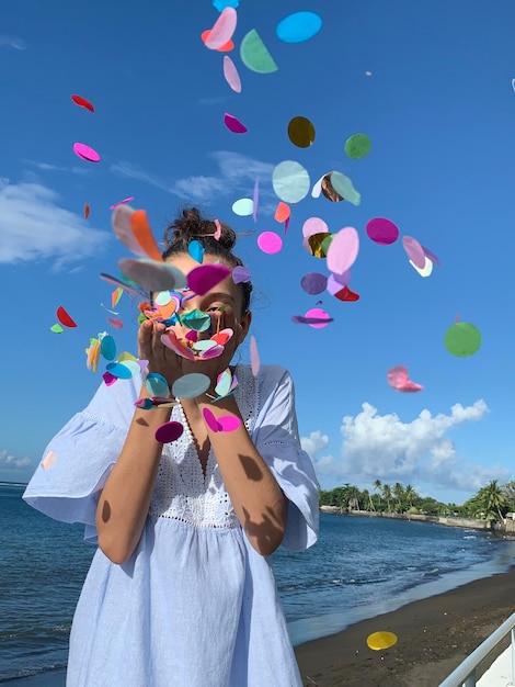 Photo femme avec des ballons dans la mer contre le ciel