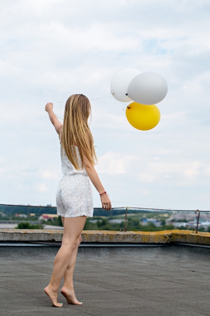 femme avec des ballons sur le toit de la maison