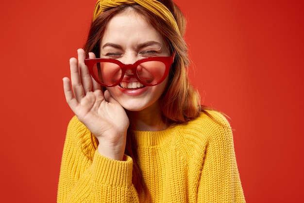 Femme avec bandeau jaune lunettes rouges mode pull jaune