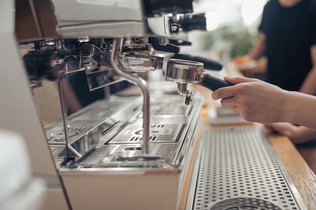 Photo femme barista à l'aide d'une machine à café professionnelle au café