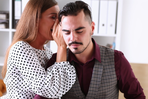 Femme bavarde à l'oreille des nouvelles à un homme