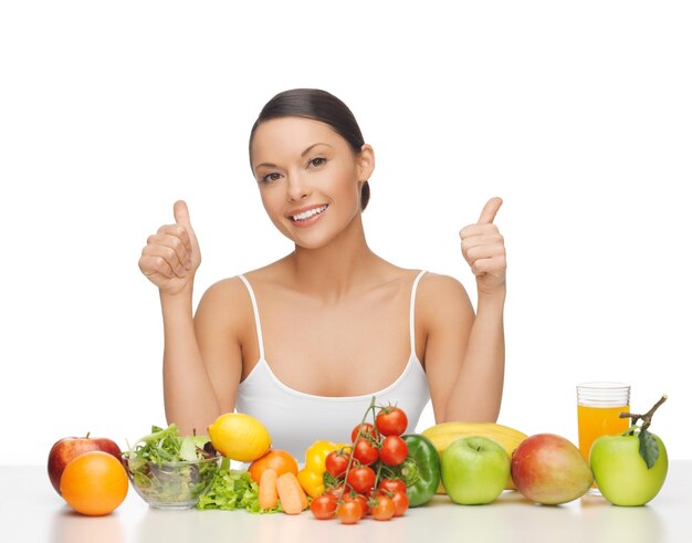 femme avec beaucoup de fruits et légumes montrant les pouces vers le haut