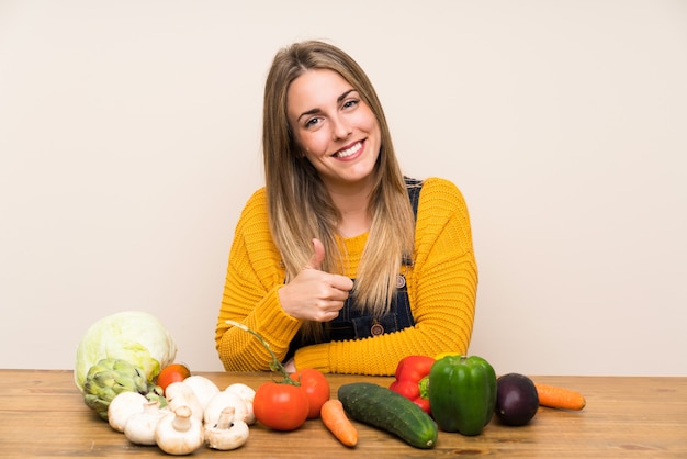 Femme avec beaucoup de légumes donnant un geste du pouce levé