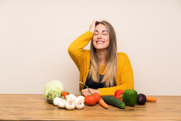 Femme avec beaucoup de légumes en riant