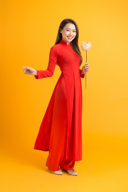 Photo femme de beauté asiatique. belle fille vietnamienne heureuse portant une robe ao dai rouge traditionnelle nationale