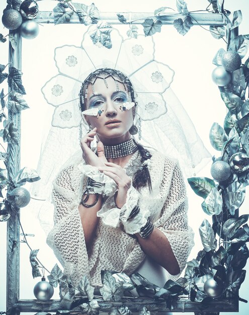 Photo femme de beauté d'hiver. maquillage de vacances. reine de l'hiver avec coiffure neige et glace