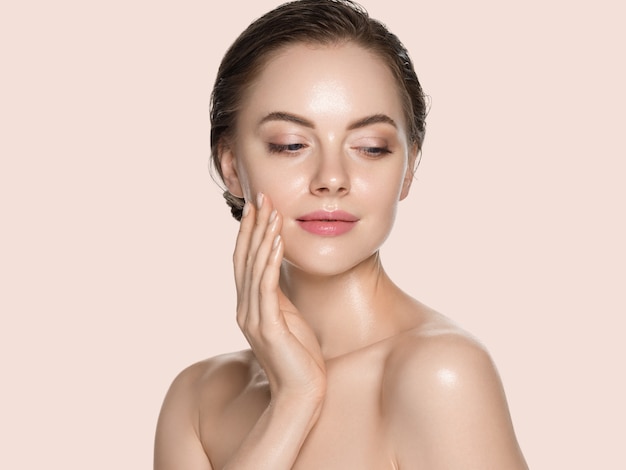 Femme de beauté avec les mains naturelles saines composent le concept de peau fraîche et propre fond de couleur jaune