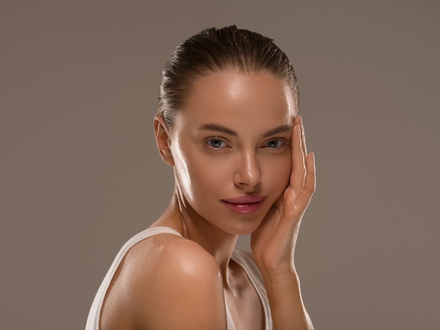 Femme de beauté avec des mains naturelles saines maquillage fond de couleur concept peau fraîche propre