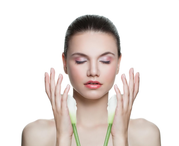 Femme de beauté avec une peau claire et saine et une fleur de lys isolée sur blanc Portrait de modèle de spa Concept de soins de la peau et du visage