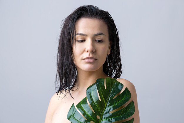 Femme de beauté avec le portrait de feuille de palmier vert naturel Cosmétiques de maquillage de beauté de mode