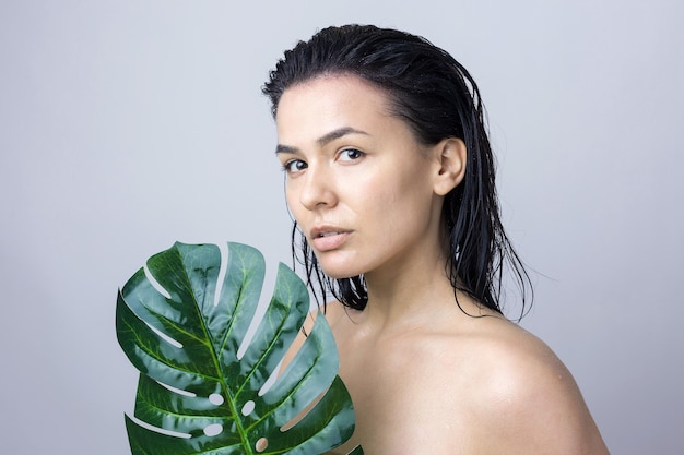 Femme de beauté avec le portrait de feuille de palmier vert naturel Cosmétiques de maquillage de beauté de mode