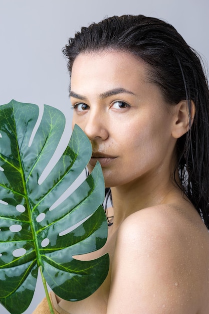 Femme de beauté avec le portrait de feuille de palmier vert naturel Cosmétiques de maquillage de beauté de mode