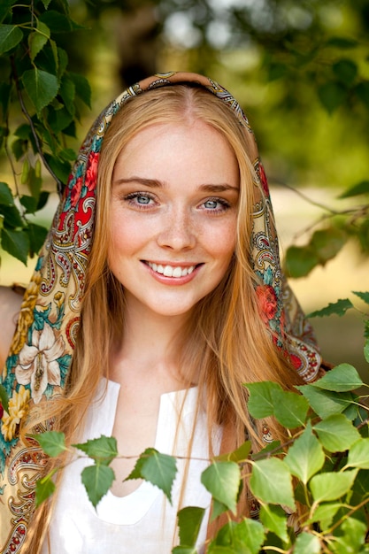 Femme de beauté russe dans l'écharpe à motifs nationale