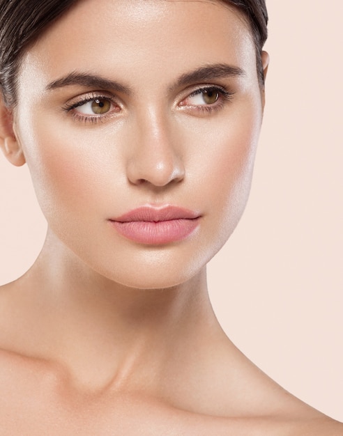 Femme beauté visage sain peau propre maquillage naturel beauté yeux femme jeune modèle Fond beige.