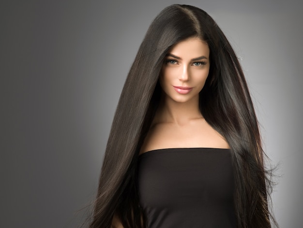 Femme de beaux cheveux avec portrait féminin de coiffure longue brune beauté saine. Prise de vue en studio.