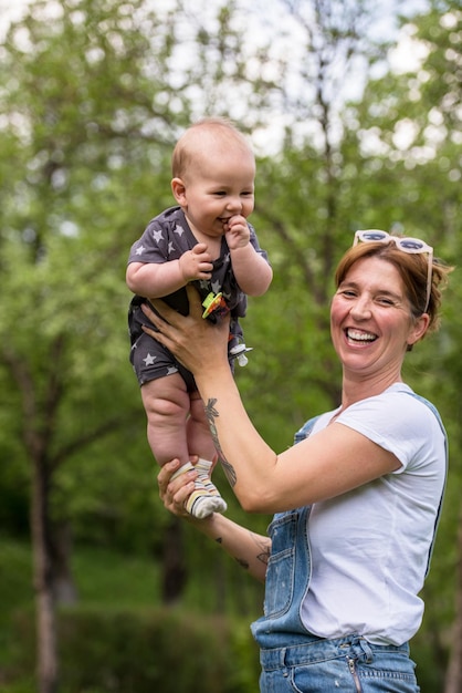 femme avec bébé s'amuser dans la nature