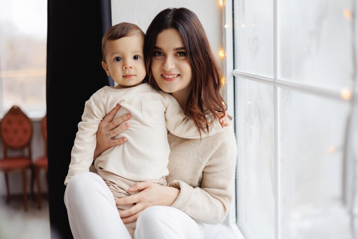 Photo une femme et un bébé sont assis sur un seuil de fenêtre