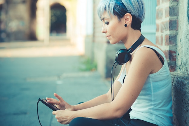 femme belle jeune hipster cheveux bleus courts avec des écouteurs musique