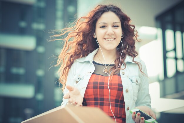 femme belle jeune hipster avec des cheveux bouclés rouges