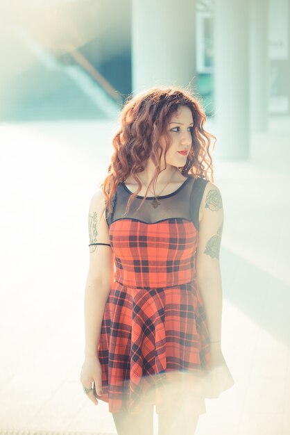 femme belle jeune hipster avec des cheveux bouclés rouges