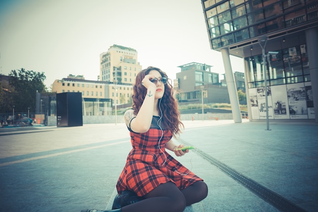 femme belle jeune hipster avec des cheveux bouclés rouges