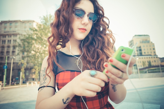 femme belle jeune hipster avec des cheveux bouclés rouges