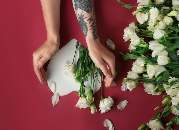 Femme avec de belles fleurs d'eustoma sur fond de couleur