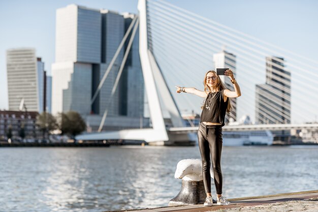 Femme bénéficiant d'une belle vue sur le paysage urbain au bord de la rivière moderne pendant la matinée dans la ville de Rotterdam
