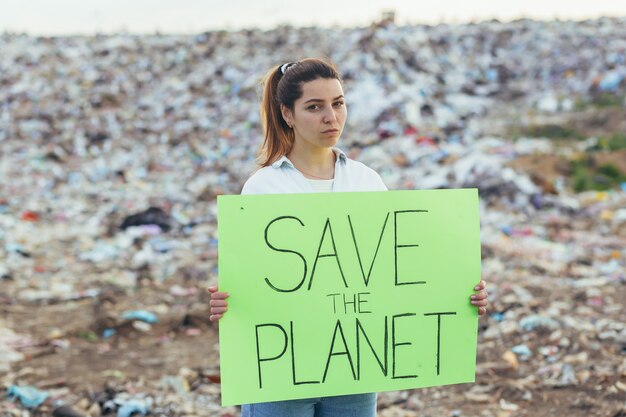 Femme Bénévole à La Décharge Tenant Une Affiche Sauver La Terre