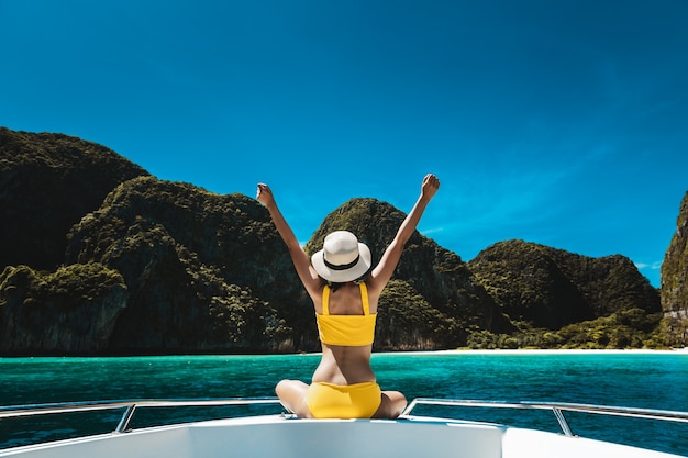 Femme en bikini assis sur un bateau