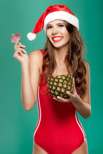 Femme en bikini boit un cocktail d'été à l'ananas