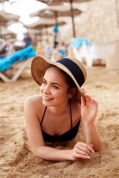 Femme en bikini et chapeau de soleil relaxant sur des plages tropicales éloignées de la plage ensoleillée
