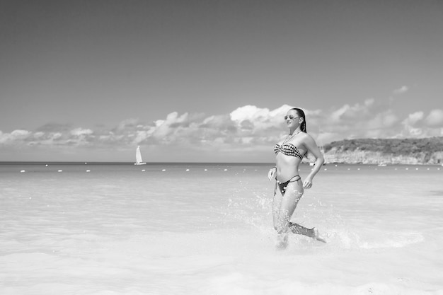 Femme en bikini courir sur la plage à st johns antigua