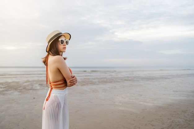 Femme en bikini debout avec les bras croisés sur la plage de la mer