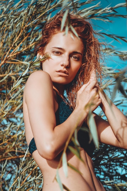 Femme en bikini sur une plage tropicale avec des plantes - heure d'été