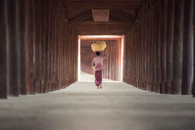 Femme birmane mettant un panier de bambou sur la tête