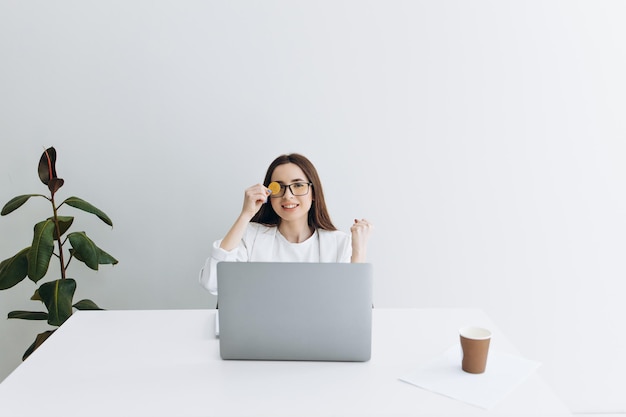 Femme avec bitcoin assis à la table sur fond gris