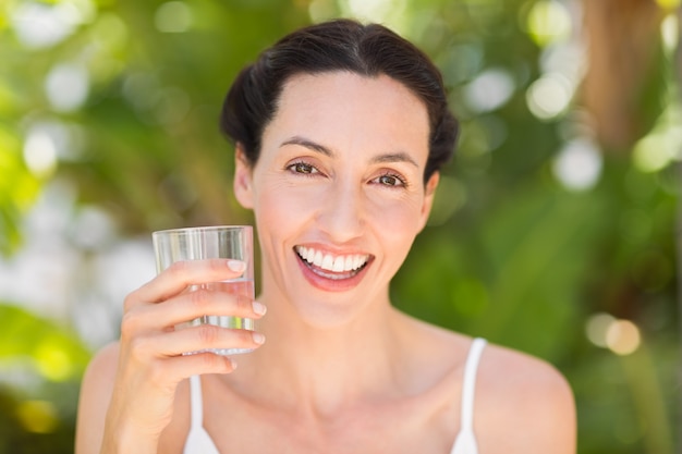 femme en blanc ayant un verre d&#39;eau