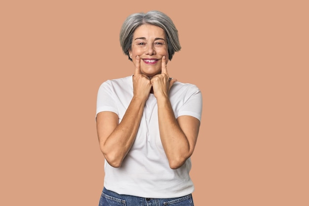 Femme blanche d'âge moyen sur le fond du studio doutant entre deux options