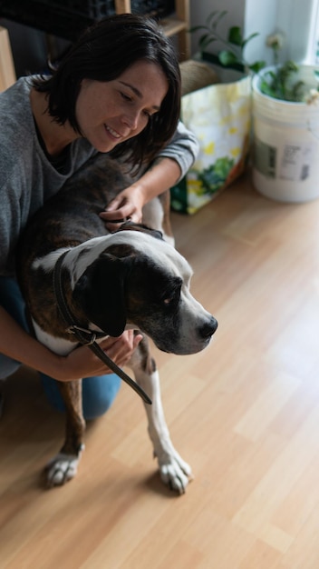 Femme blanche caressant et aimant un chien boxer