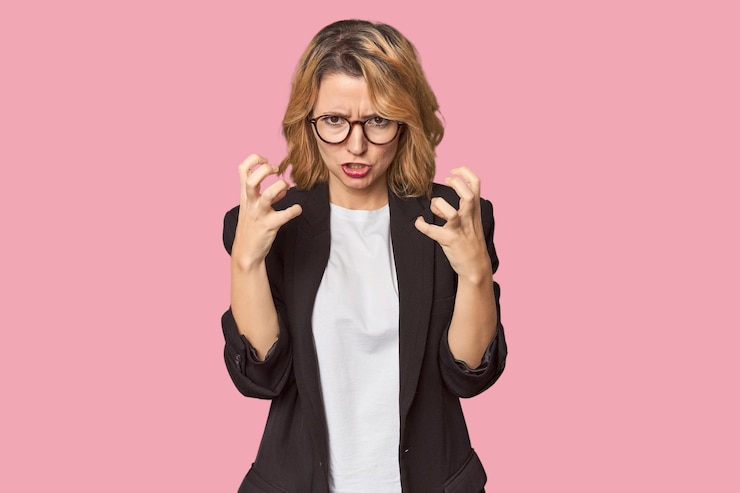 Photo une femme blanche en costume d'affaires noir, en colère, criant avec les mains tendues.