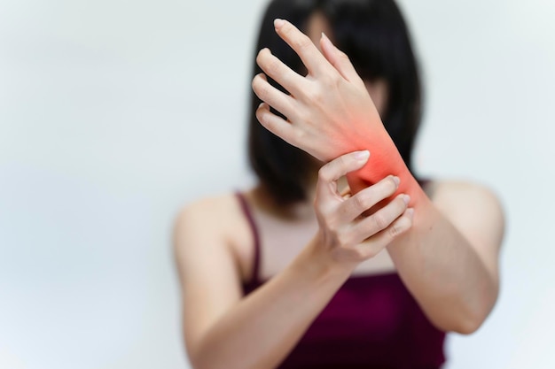 Femme avec blessure au poignet sur fond gris