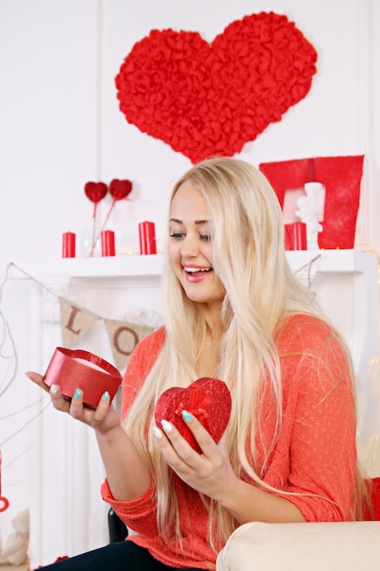 Femme blonde avec une boîte en forme de coeur