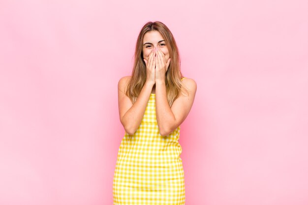 Femme blonde à la bouche heureuse, joyeuse, chanceuse et surprise couvrant les deux mains