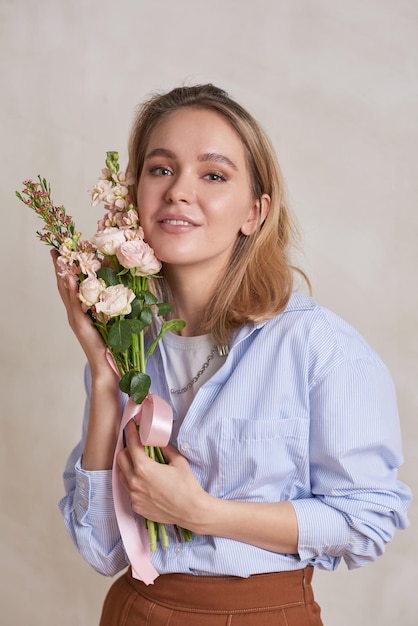 Femme blonde avec bouquet de fleurs