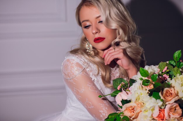 Femme blonde avec bouquet de mariée en mains