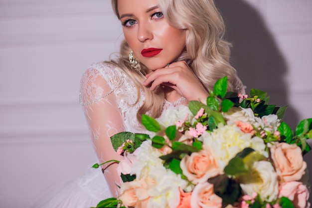 Femme blonde avec bouquet de mariée en mains